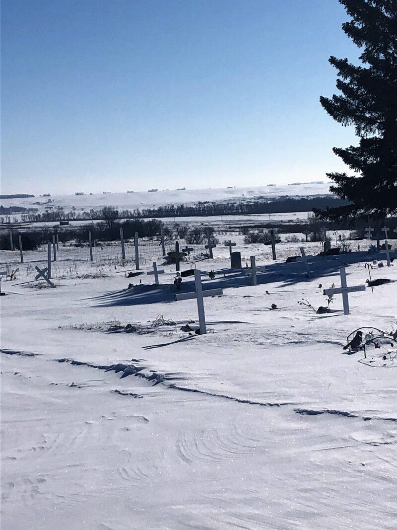 Cemetery in the winter, showing rows of white crosses marking graves