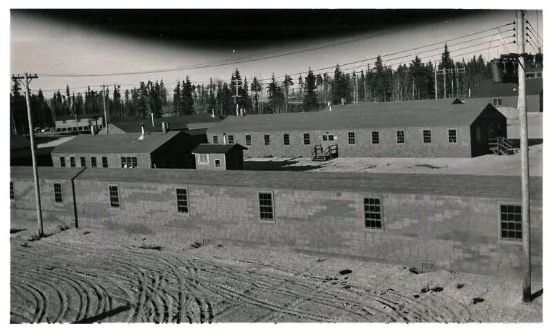 Exterior view of a group of long, single-storey buildings.