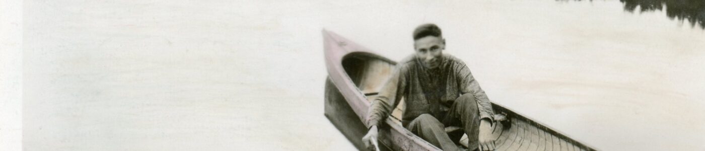 A man in a canoe on a body of water. From album page MBLung-11-14-001