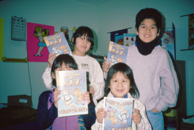 Four children holding up a magazine called "The Adventures of Raz: Raz Learns About Tuberculosis"