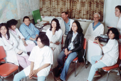 A group of people watching a slide show. Many of them are wearing bath robes.