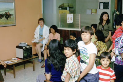 A group of people gather around a slide viewer.