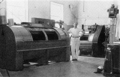 A man stands next to a large machine.