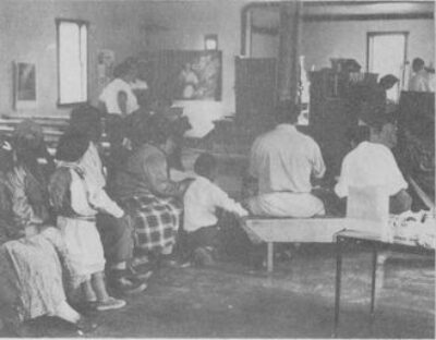 A group of people sitting at a church. View from the back of the room.