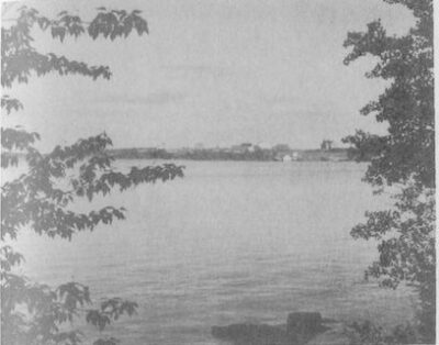 A lake view. Trees line each side of the frame.