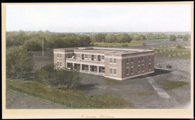 The exterior view of a building from a distance. A tree-lined landscape borders the building, and a field with haystacks can be seen behind the building. An annotation on the photo mat reads: "St. Boniface Preventorium"