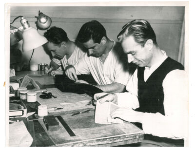 Three men doing leather work