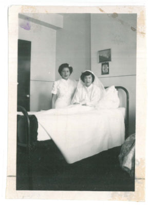 Woman in bed wearing a white veil with a nurse