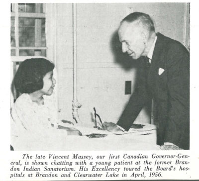 A young girl sitting in bed smiling at a man in a suit. A printed caption reads: "The Late Vincent Massey, our first Canadian Governor-General, is shown chatting with a young patient at the former Brandon Indian Sanatorium. His Excellency toured the Board's hospitals at Brandon and Clearwater in April, 1956"