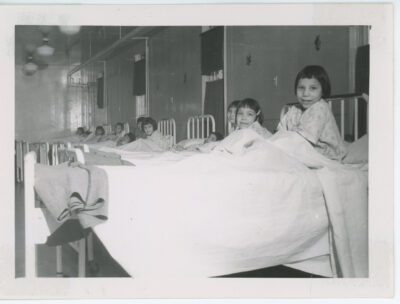 A row of girls in hospital beds.