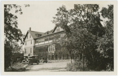 Exterior view of the Ninette Sanatorium with vehicles parked in front.