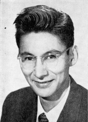 A portrait of a man wearing a suit and glasses.