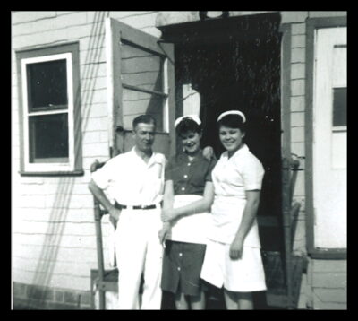 A man and two women stand in the doorway of a building.